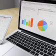 Laptop displaying colorful charts and graphs next to a tablet showing data insights.